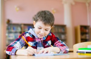 Leraar en leerling staan bij het schoolbord voor een wiskunde opdracht.