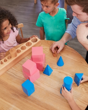 Jonge kind: kinderen worden begeleid door leerkracht met blokkenspel voor rekenen