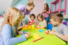 Kinderen vouwen blaadjes aan een tafel