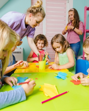 Kinderen vouwen blaadjes aan een tafel