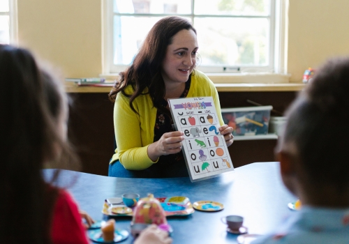 Jonge Kind - Leerkracht laat letters aan jonge kinderen zien