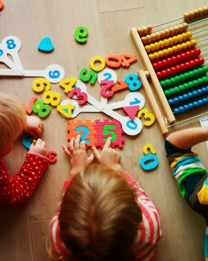 Jong kind met donkerbruin haar schrijft aan tafel in een schrift