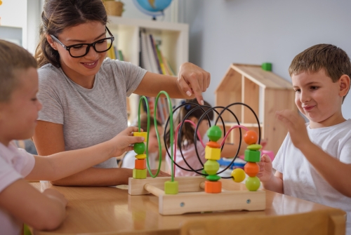 Leraar speelt samen met een kind aan tafel