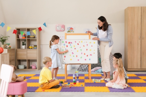 Letters op het schoolbord Kinderen en leraar met letters op het schoolbord