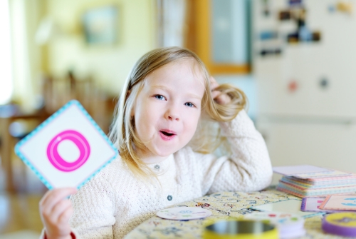 Meisje oefent letters Meisje houdt de letter O omhoog