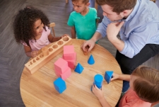 Spelbegeleiding - Foto van leerkracht die met kinderen aan een tafel speelt met blokken